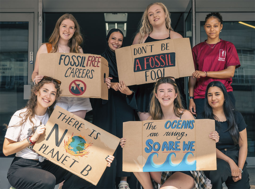 HSU Officer 2024/25 smiling and holding climate-related cardboard placards.