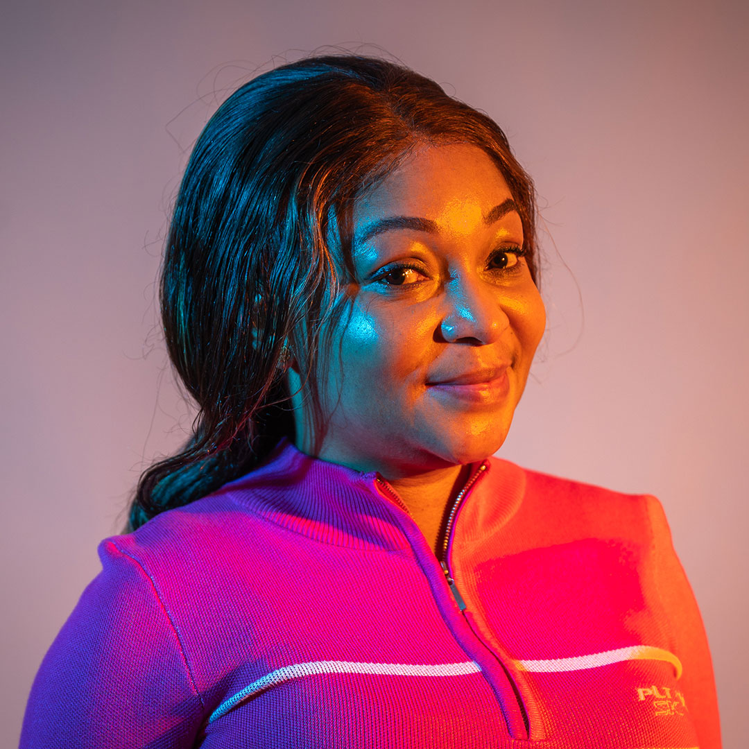 Headshot of Iye Orok backlit with purple light