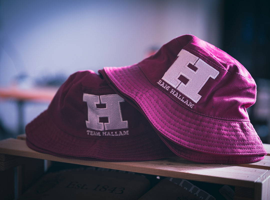 Two Hallam branded bucket hats on a table