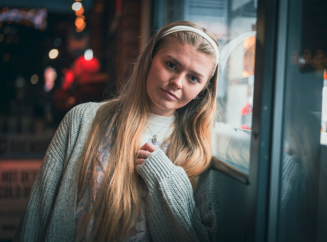 Student leaning on a shop window